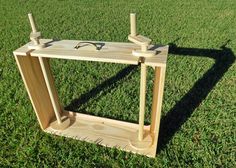 a wooden frame sitting on top of a lush green field