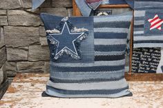 a blue pillow with a star on it sitting next to some other pillows and wall hangings