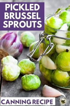 a jar filled with brussel sprouts next to garlic and an onion