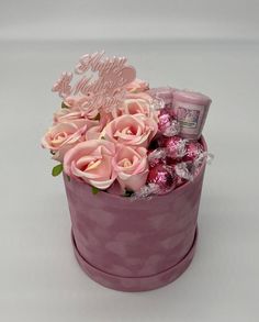 a pink hat box filled with candy and flowers