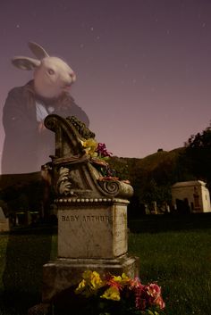 a rabbit statue sitting on top of a grave