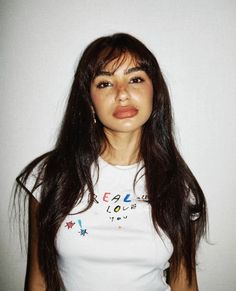 a woman with long brown hair wearing a white shirt