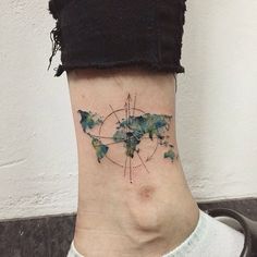 a woman's neck with a small world map tattoo on her left side ribcage