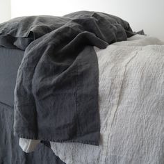 an unmade bed with black and white linens