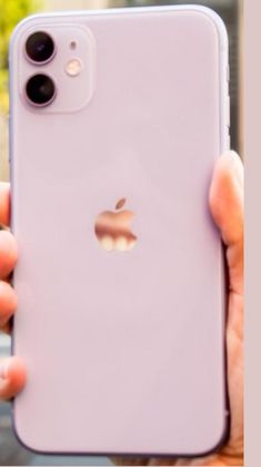 a person holding an iphone in their hand with the back cover partially open to show the apple logo