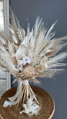 an arrangement of dried flowers in a wicker basket