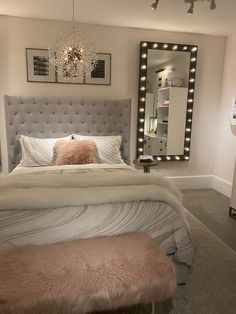 a bedroom with a bed, mirror and bench