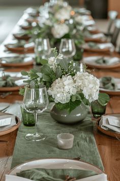 the table is set with green and white flowers