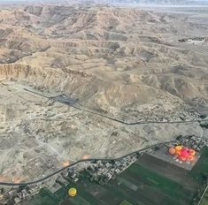 an aerial view of the desert with hot air balloons