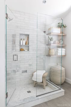 a walk in shower sitting next to a white brick wall with shelves on the side