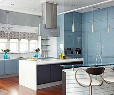 a modern kitchen with blue and white cabinets, counter tops, and bar stools