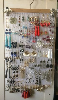 a wall mounted jewelry rack with lots of earrings