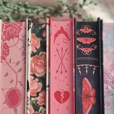 four books lined up on top of each other in different colors and designs with flowers