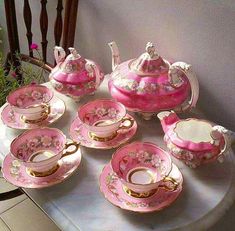 pink and gold tea set with matching saucers