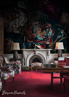 a living room with floral wallpaper and red carpeted flooring, two lamps on either side of the fireplace