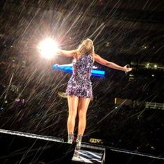 a woman standing on top of a stage in the rain