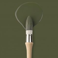 a close up of a paint brush on a green background with the tip pointing upward