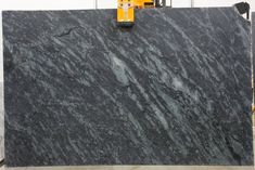 a large black marble slab being worked on