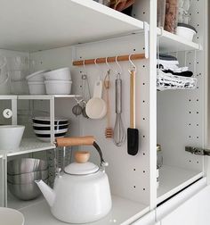 a kitchen with white shelving and utensils