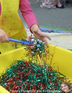 a child in a yellow tub filled with tinsel and sprinkles,