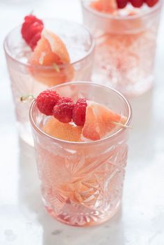 three glasses filled with fruit on top of a table