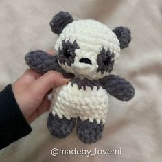 a hand holding a small crocheted teddy bear