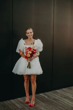 a woman in a white dress holding flowers