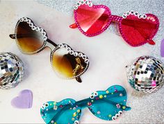 Three pairs of handmade sunglasses with rhinestones and charms. Champagne problems, Cruel Summer, and In My Eras Era on the glasses. For sale on Etsy! Eras Tour Movie Party, Taylor Swift Sunglasses Beads, What To Wear To The Eras Tour, Taylor Swift Heart Glasses Diy, Taylor Swift Heart Sunglasses, Eras Tour Heart Glasses, Easy Eras Tour Outfits, Maddie Taylor