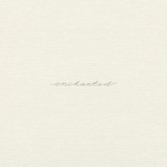 the word enchanted written in cursive writing on a white paper background