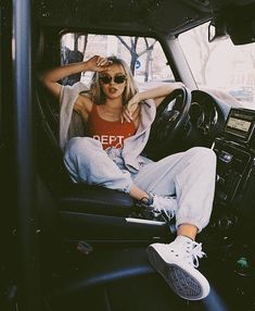 a woman sitting in the driver's seat of a car