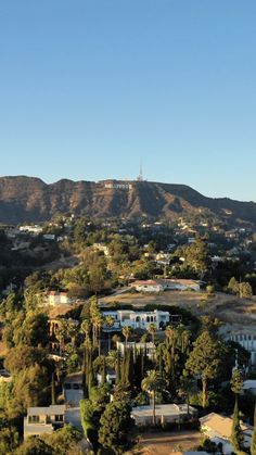 an aerial view of the city with mountains in the backgrouund and houses on the other side