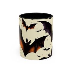 a black and white mug with bats on it's side, in front of a white background