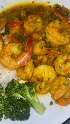 shrimp, broccoli and rice on a white plate with garnishes