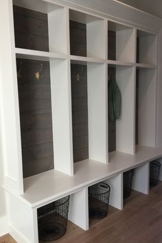 some white shelves with baskets on them in a room