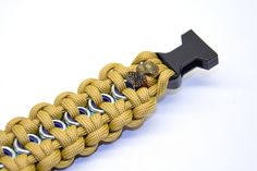 a yellow paracording bracelet with metal clasps and black buckle on white background