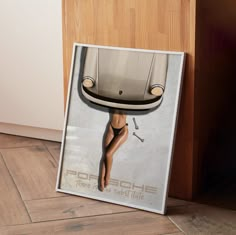 an advertisement for the porsche brand is displayed in front of a wooden cabinet and floor