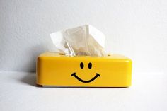 a tissue dispenser with a smiley face on it