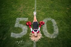 a cheerleader laying on the ground with her hands behind her head and flowers in her hair