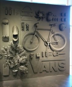 an advertisement for vans with a bicycle and plants on it's display wall in front of a window