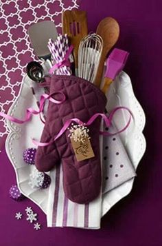 a purple oven mitt sitting on top of a white plate next to utensils