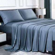 a bed with blue sheets and pillows in a room