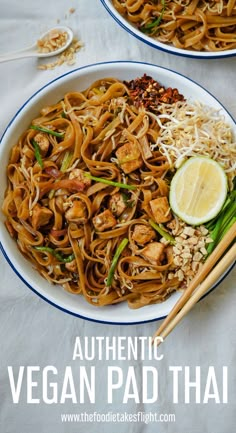 two white plates filled with noodles and vegetables next to chopsticks on a table