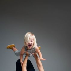 a woman holding a small child in the air