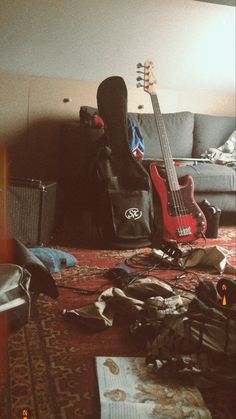 a guitar and other musical instruments are on the floor in front of a couch,