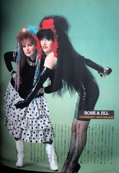 two women dressed in black and white are posing for a magazine cover with long hair