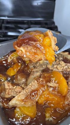 a close up of food in a pan on top of a stove with a spoon