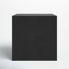 a black cube sitting on top of a white floor