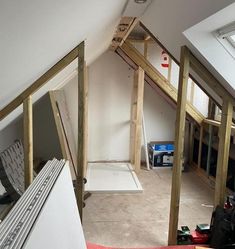 an attic with unfinished walls and flooring in the process of being built into the wall