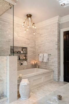 a bathroom with a large tub and chandelier hanging from it's ceiling