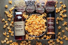 an assortment of snacks and condiments on a wooden table, including caramel popcorn